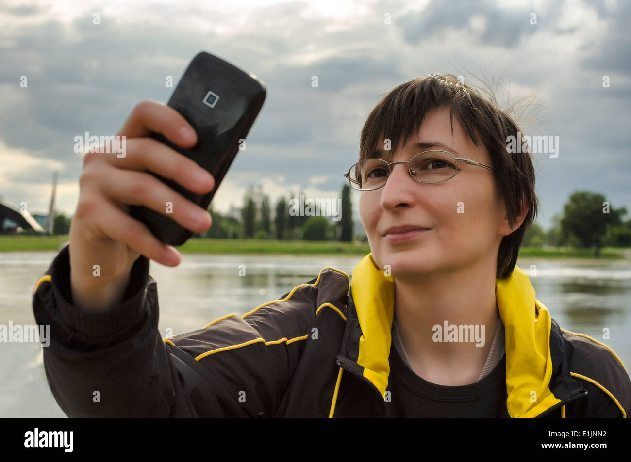 Woman in nature taking selfie using smart phone. Stock Photo