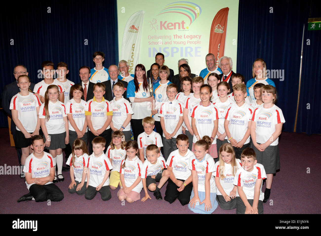 Local school children proudly gather with famous faces to show off the Queen's baton in Maidstone Kent UK . Stock Photo