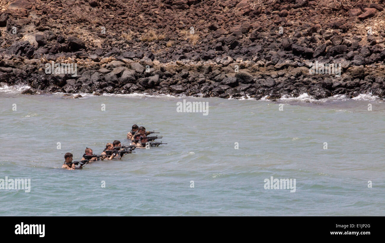 U.S. Marines with the 26th Marine Expeditionary Unit's maritime raid force clear water out of their M4 carbines during an amphi Stock Photo