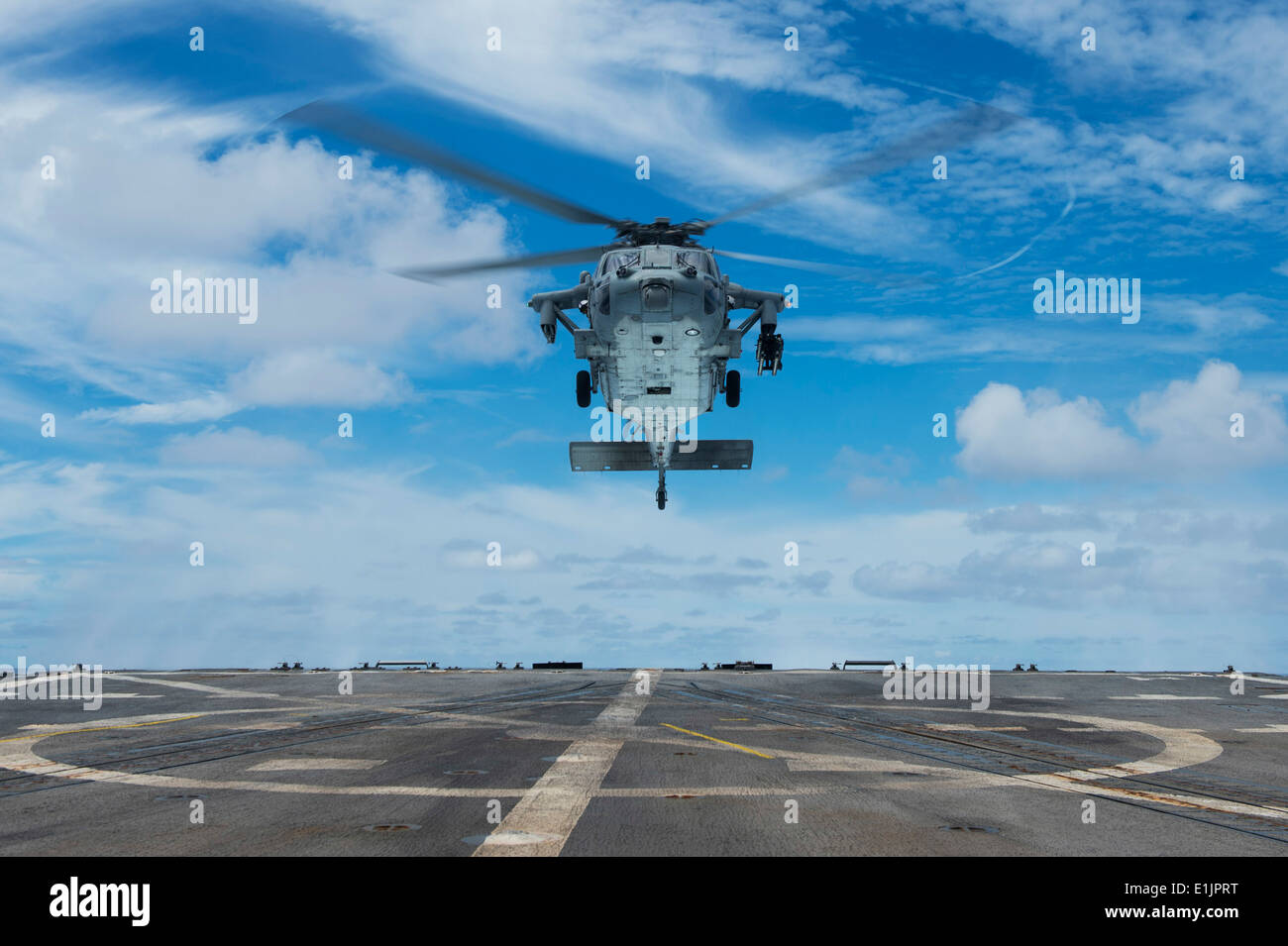 A U.S. Navy MH-60S Seahawk helicopter assigned to Helicopter Sea Combat Squadron (HSC) 12 prepares to land aboard the guided mi Stock Photo