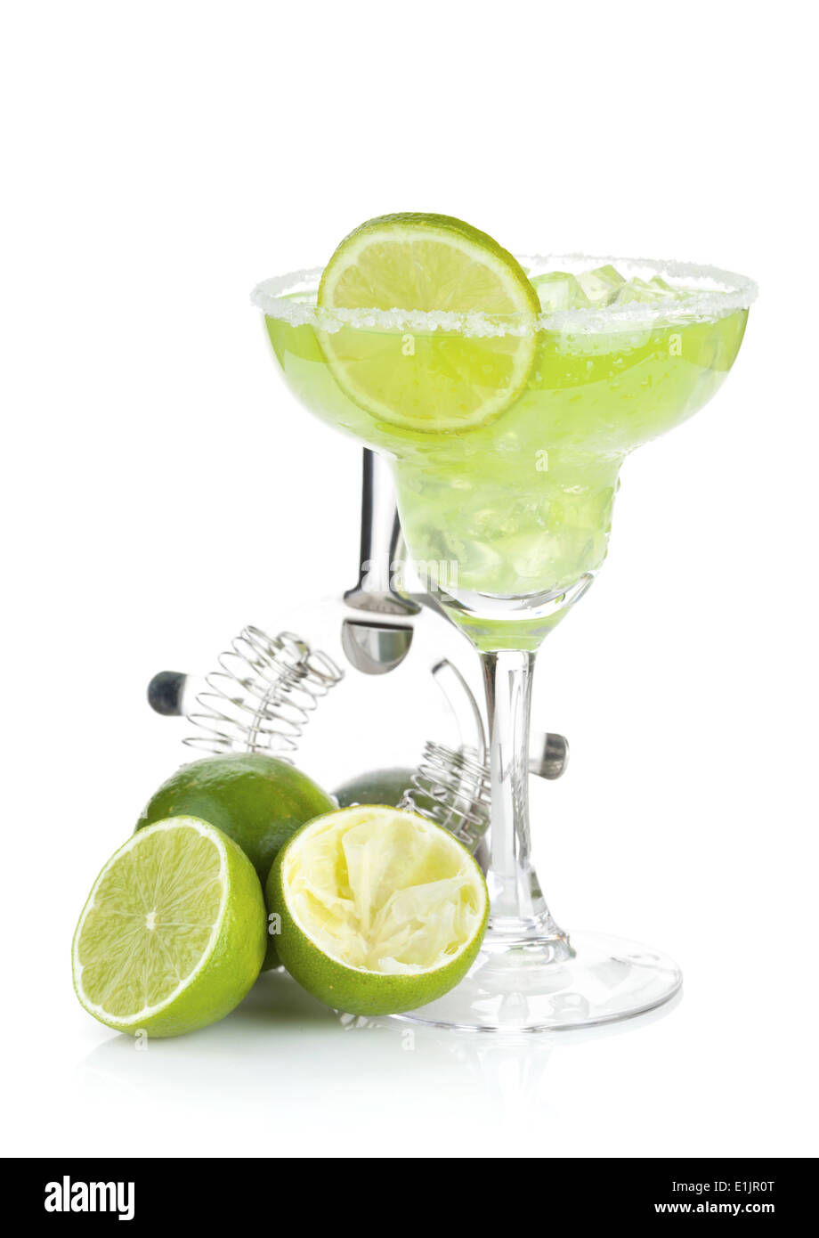Classic margarita cocktail with salty rim, limes and drink utensils ...