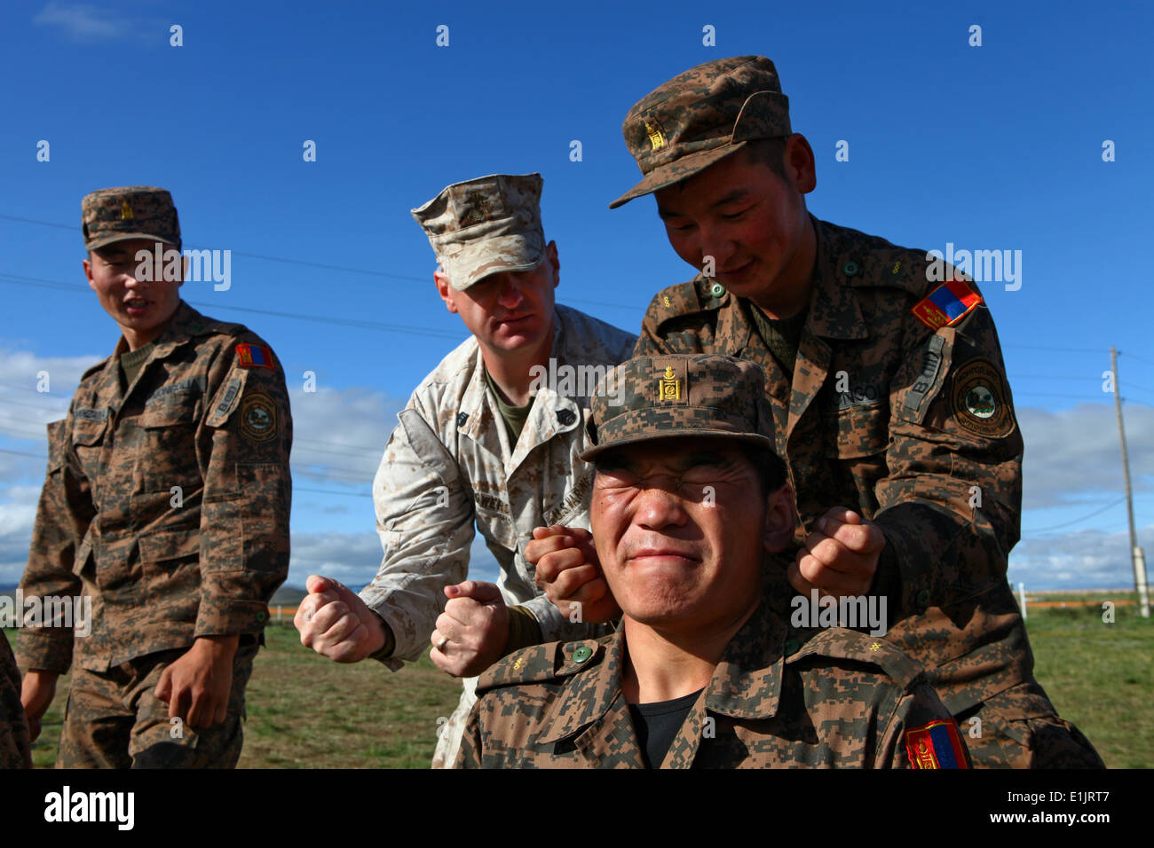 Mongolian Armed Forces Junior Sgt. G. Enkhtuushin rehearses a pressure point strike on Junior Sgt. U. Bazarvaani following a de Stock Photo