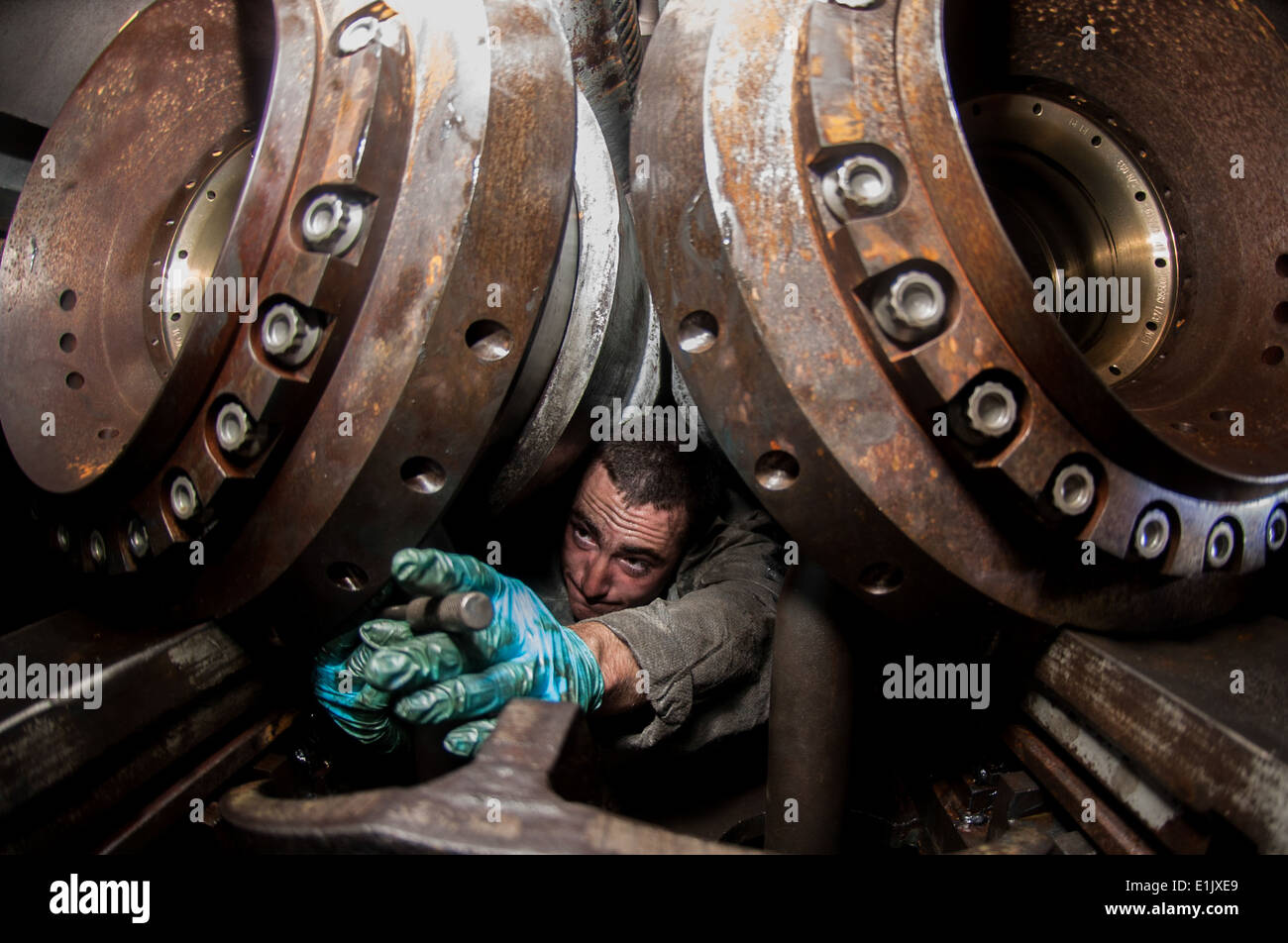 U.S. Navy Aviation Boatswain's Mate (Equipment) Airman Tyler Dufford tightens a bolt on a water