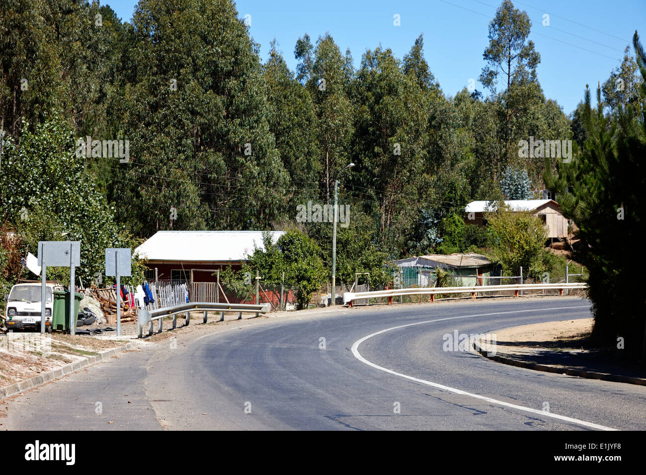 sharp bend on the coastal road with small houses los pellines chile Stock Photo