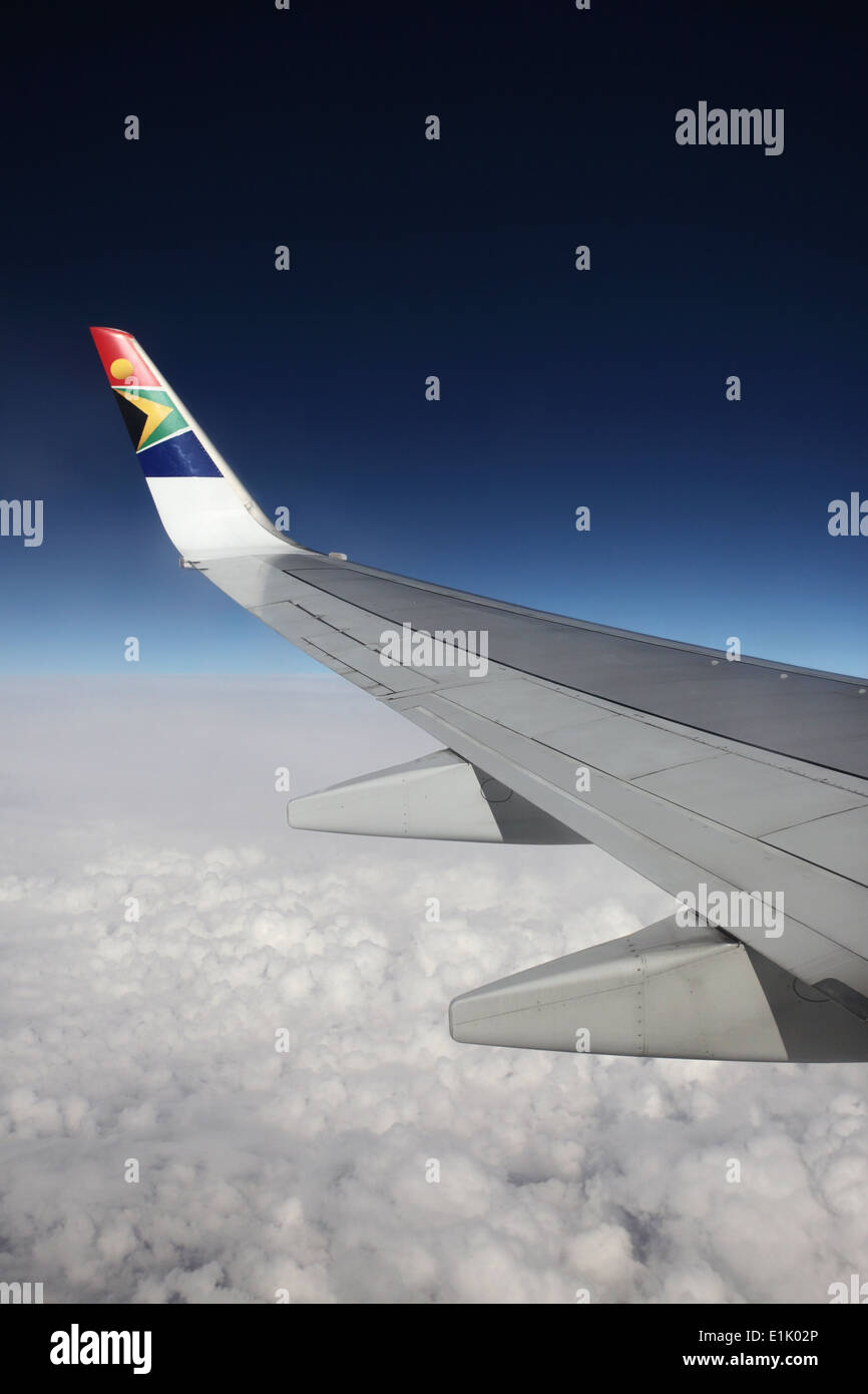 Wingtip of a South African Airways SAA aircraft flying over clouds Stock Photo