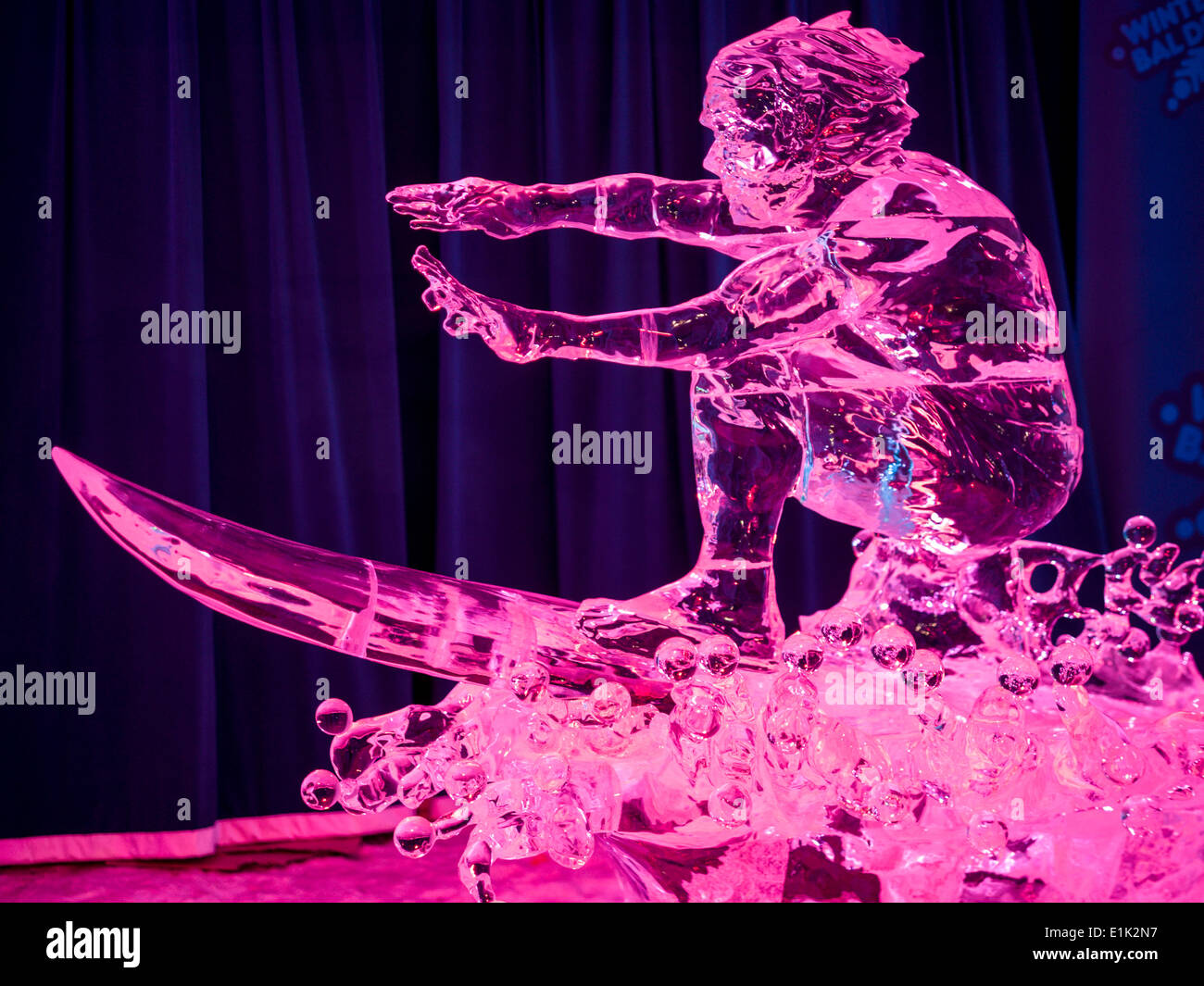 Freeze Frame: Surfing the Frozen Wave. An ice sculpture of a surfer riding his surfboard on a bubbling wave. Stock Photo