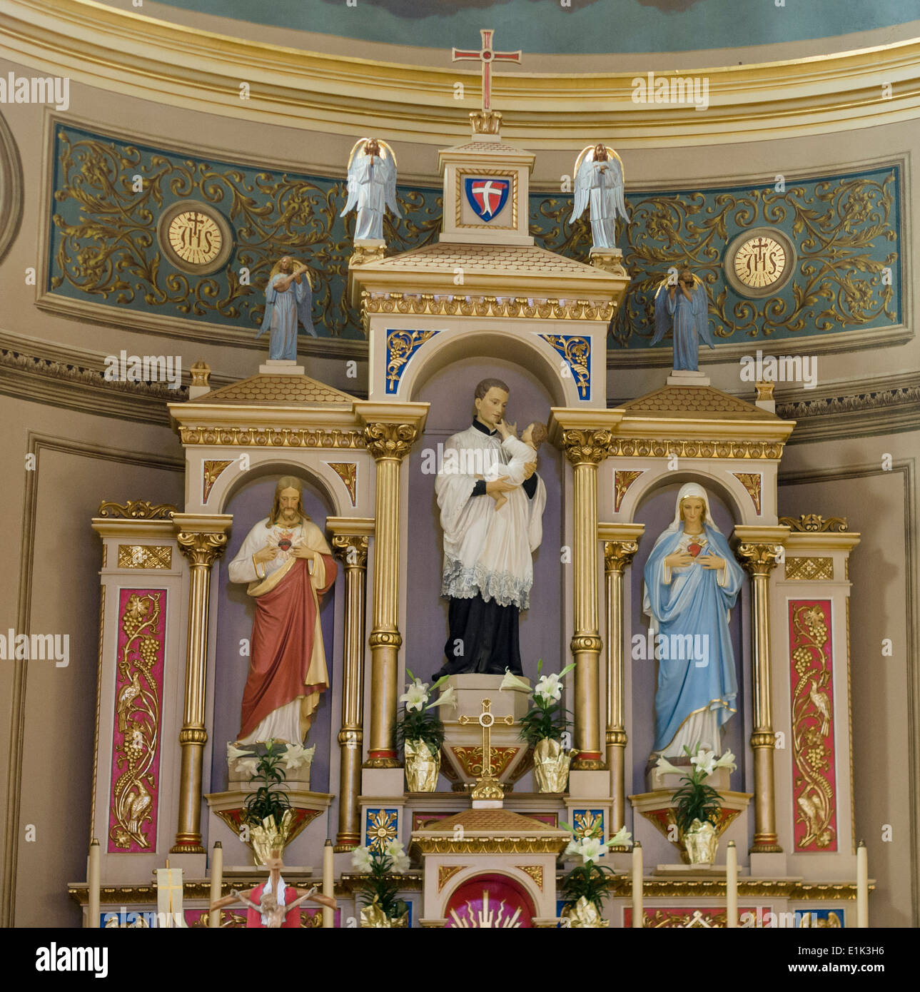 Detail of the Altar at St Stanislaus Roman Catholic Polish Church. Jesus and Mary flank a priest holding a baby in the ornate ca Stock Photo
