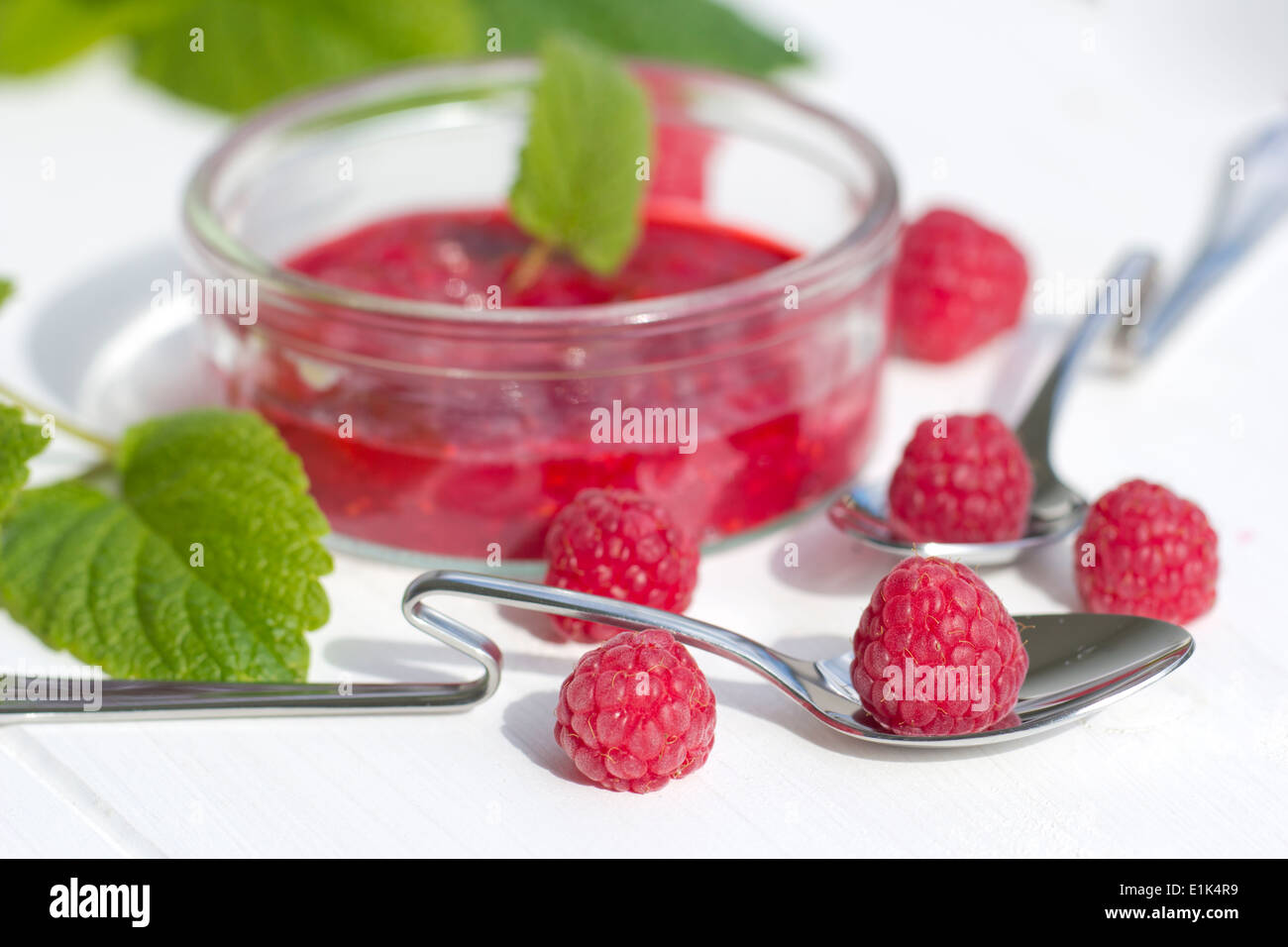 Mashed Raspberries Mashed raspberries in a glass, raspberry on spoon, lemon balm Stock ...