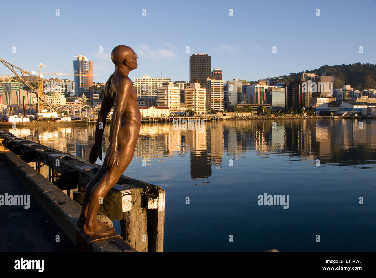Office buildings on waterfront at dawn, Wellington, North Island, New Zealand, Bronze Solace in the Wind sculpture in foreground Stock Photo