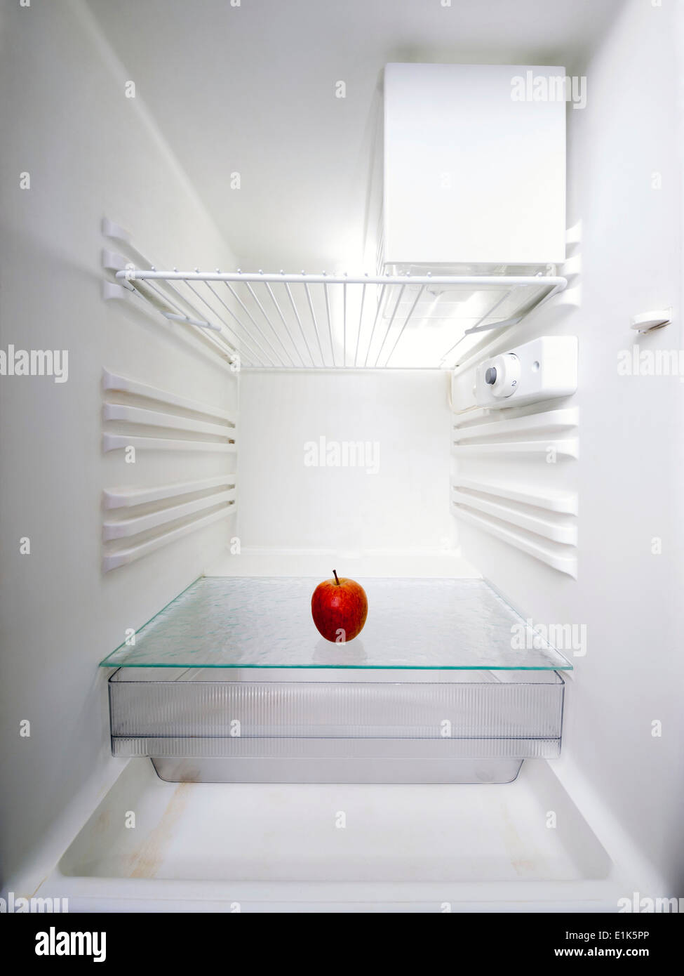 Red apple in an empty fridge. Stock Photo