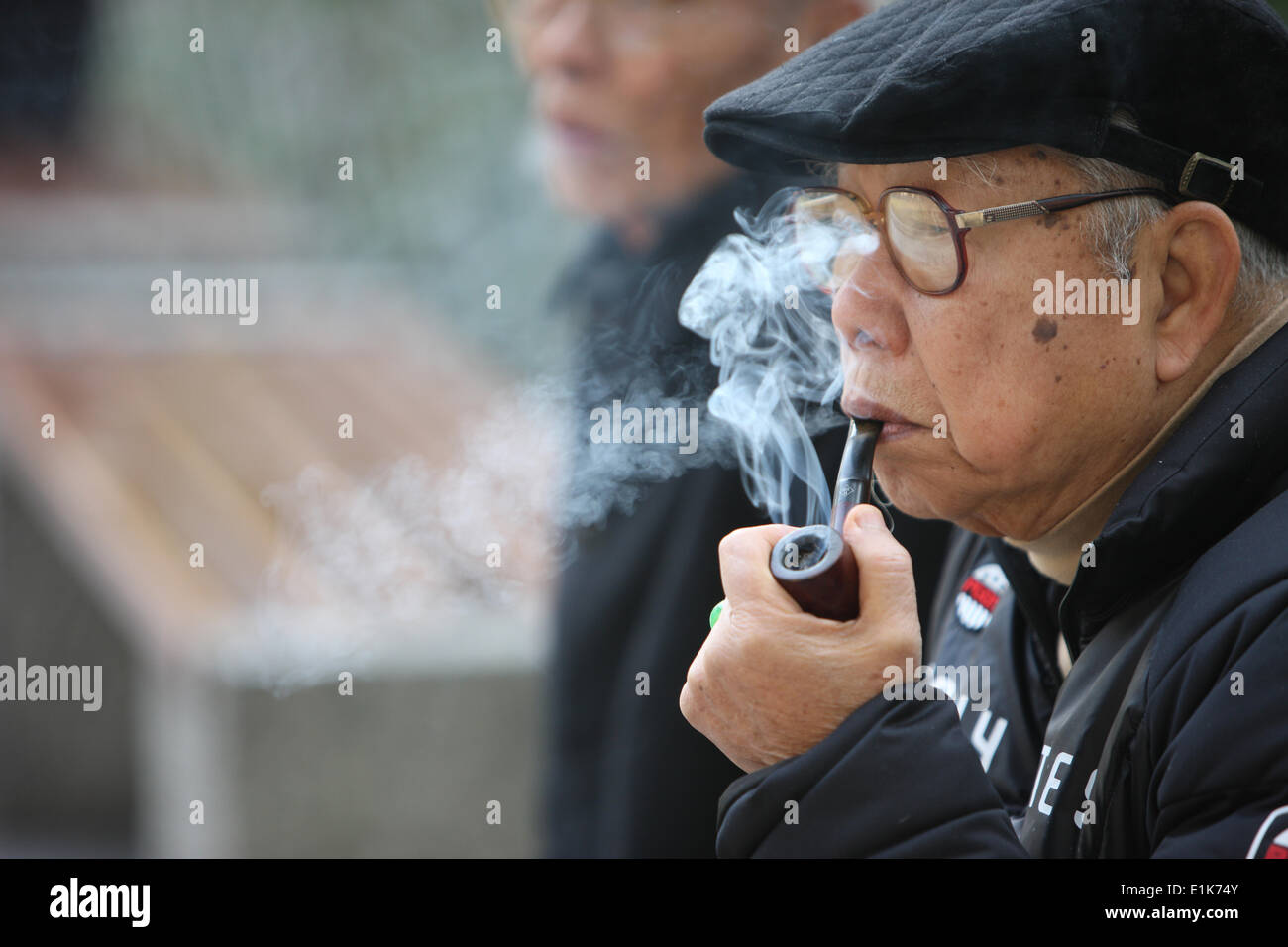 Old man smoking a pipe. Stock Photo