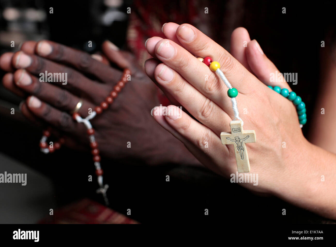 African praying the rosary. Man and woman praying together in a church. Stock Photo