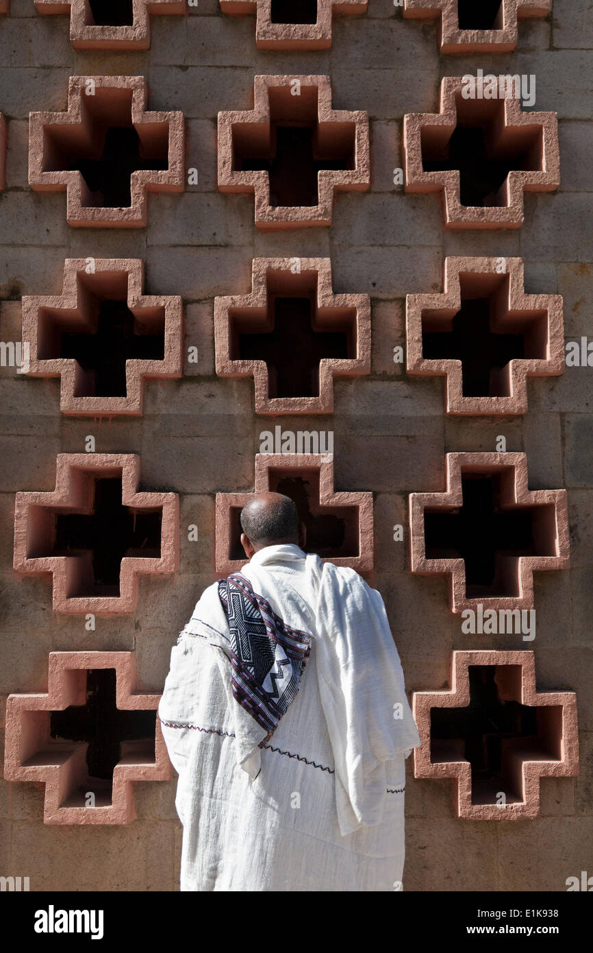 Man praying in front of a church wall in Addis Ababa. Stock Photo