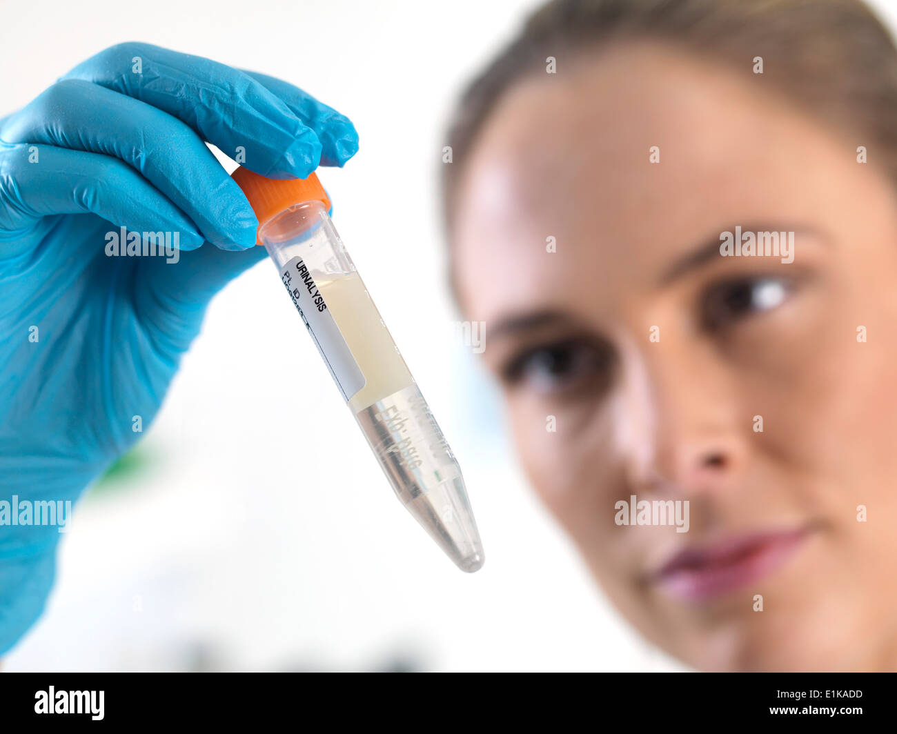 Female scientist holding an eppendorf tube with liquid inside. Stock Photo