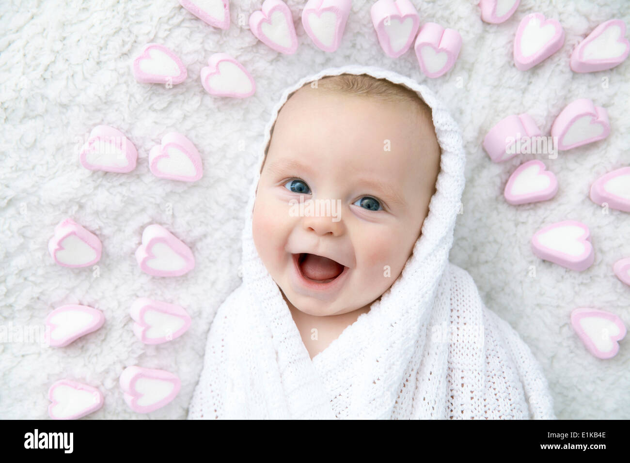MODEL RELEASED Baby boy wrapped in blanket with heart shapes around his