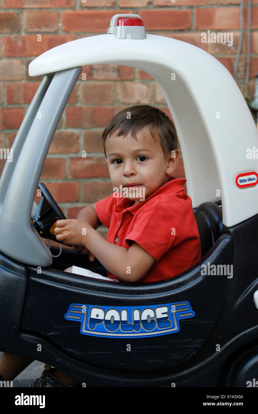 3-year-old boy driving a toy car Stock Photo