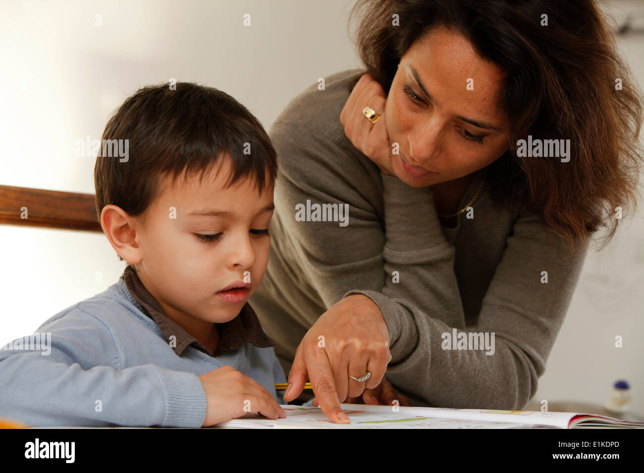 Mother helping a 6-year-old boy with his homework Stock Photo