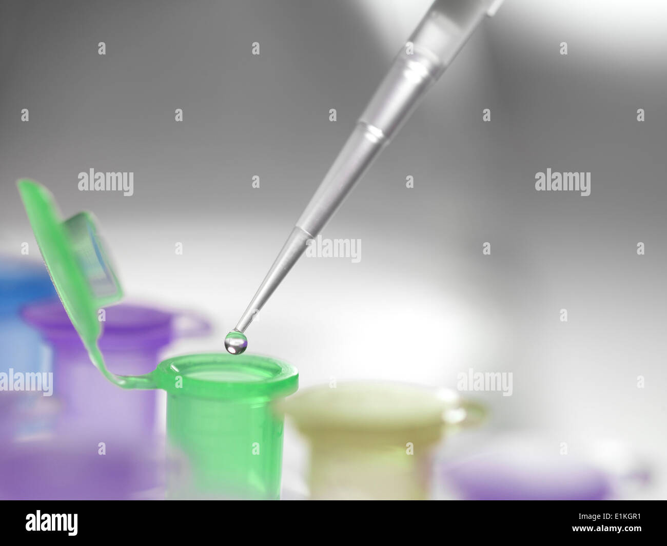Pipette dropping a solution into a vial used for storing liquid during