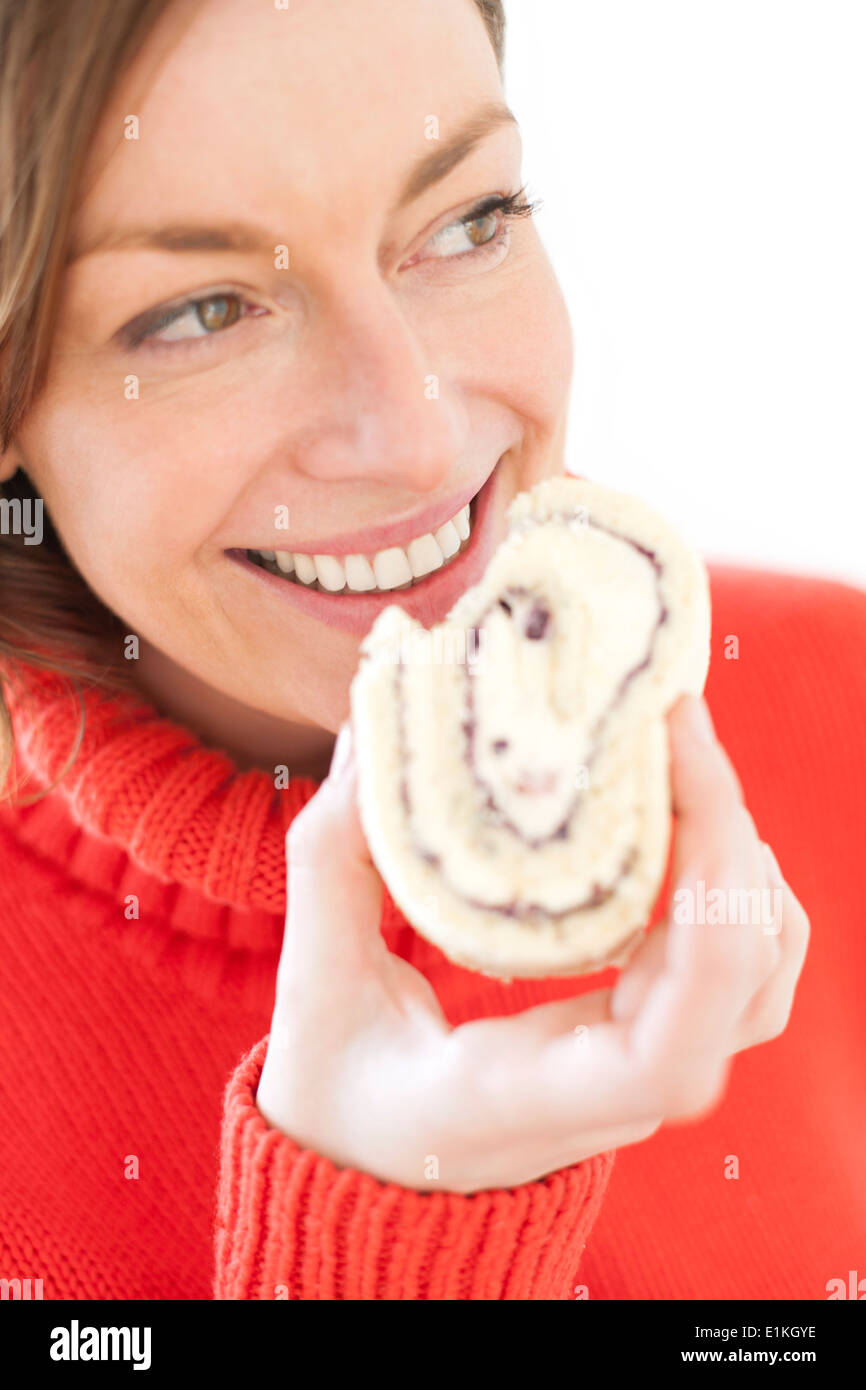 MODEL RELEASED Woman biting into a piece of cake. Stock Photo