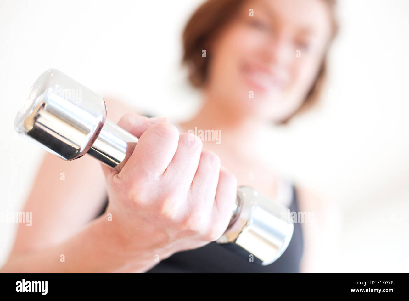 MODEL RELEASED Woman using hand weight. Stock Photo
