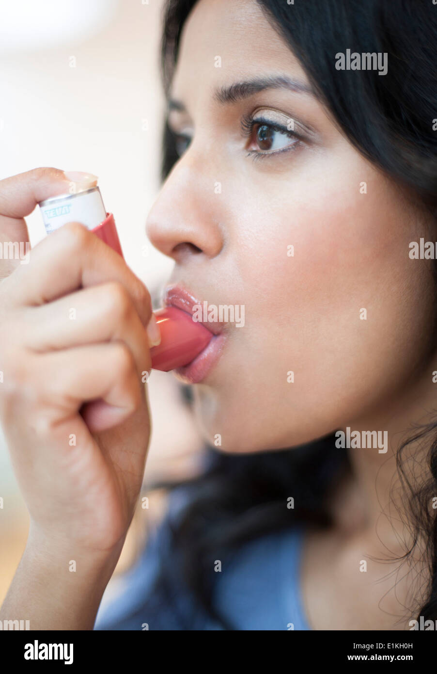 MODEL RELEASED Woman using an inhaler. Stock Photo