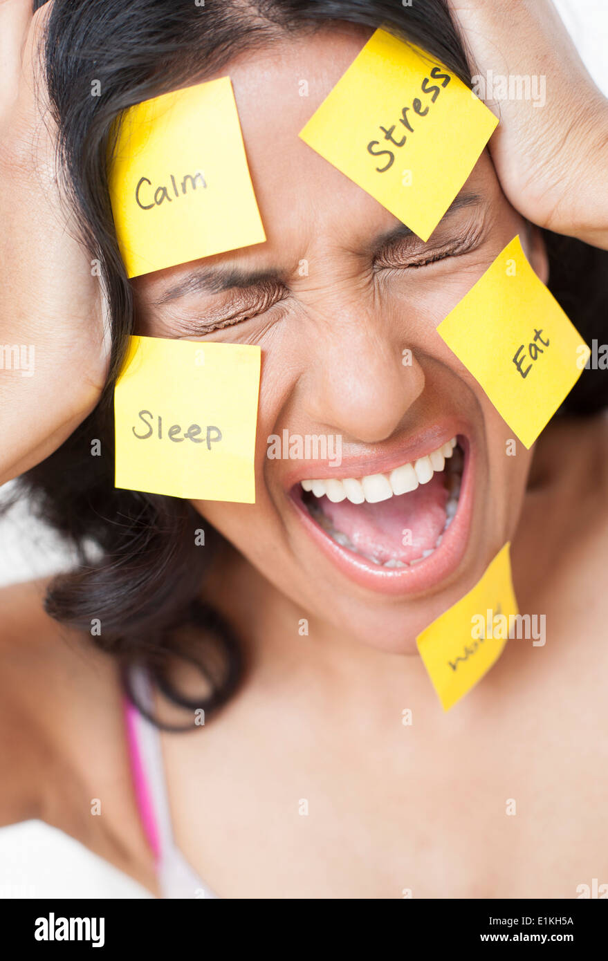 MODEL RELEASED Frustrated woman with adhesive notes stuck to her face. Stock Photo