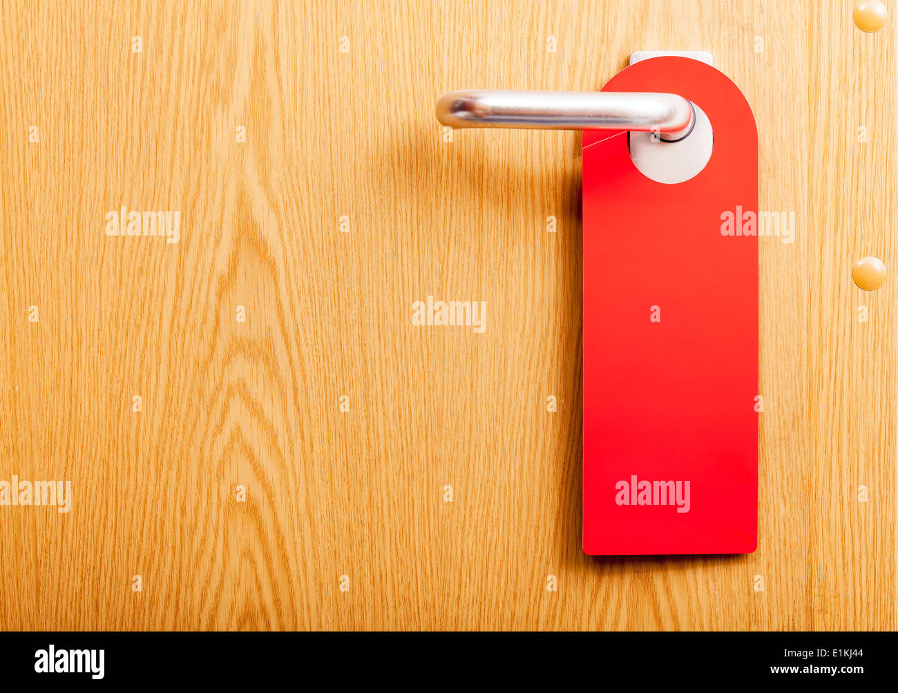 Red door tag on the handle of a closed door. Stock Photo