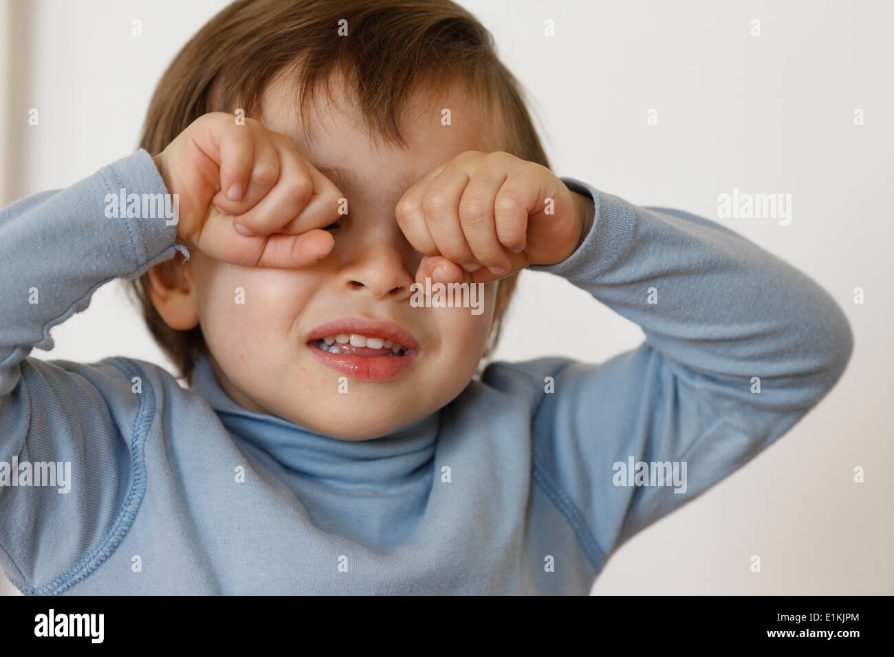 3-year-old boy rubbing his eyes Stock Photo