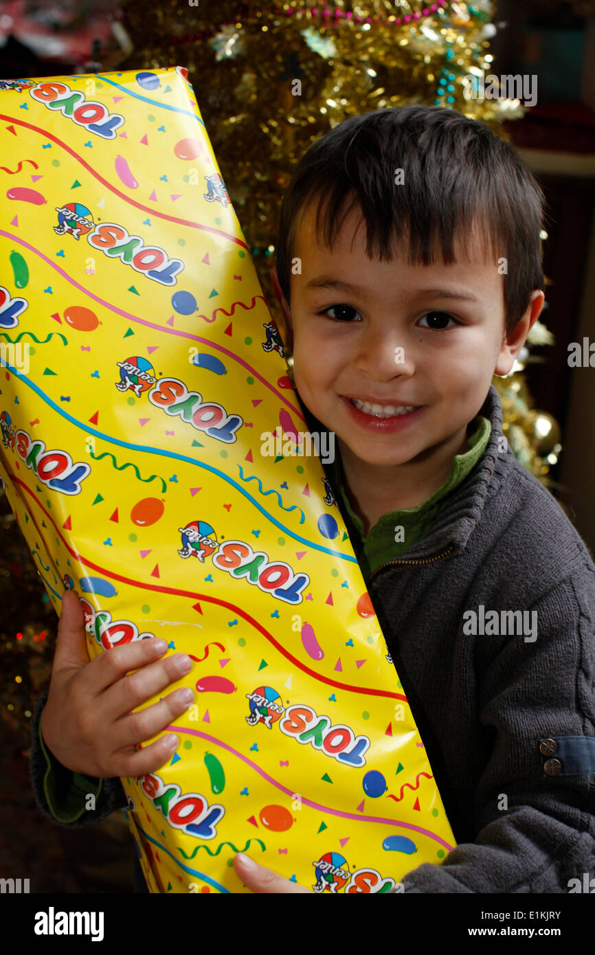 5yearold boy holding a Christmas present Stock Photo Alamy