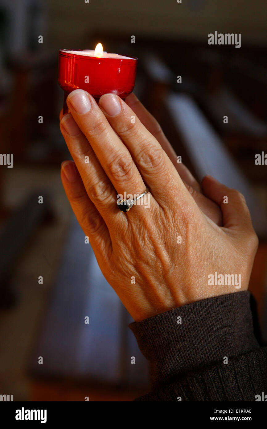 Woman praying with a candle Stock Photo Alamy