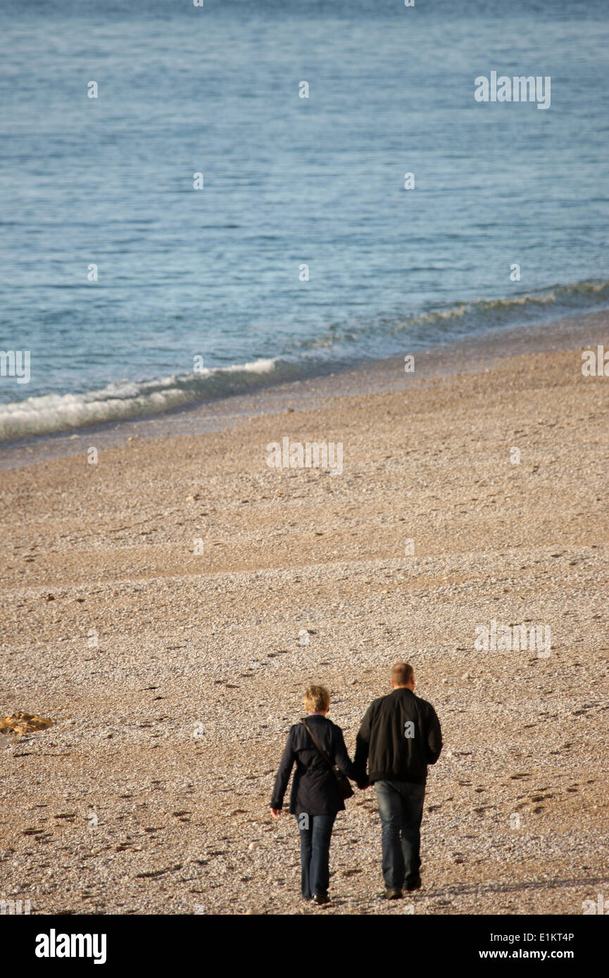 Couple walking on a beach. Stock Photo