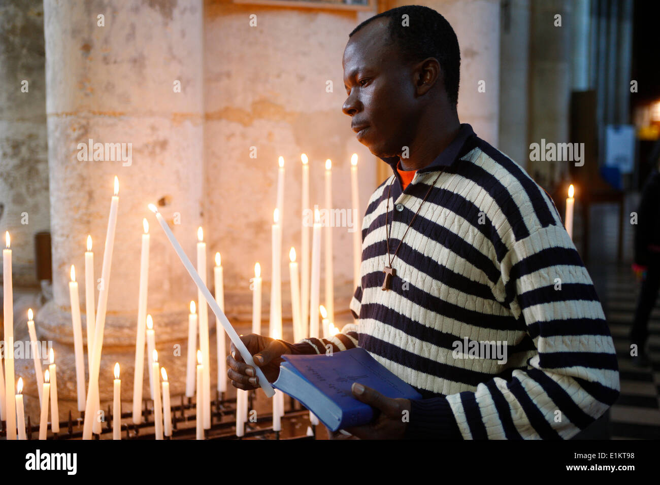 Man praying with candles in church Stock Photo Alamy