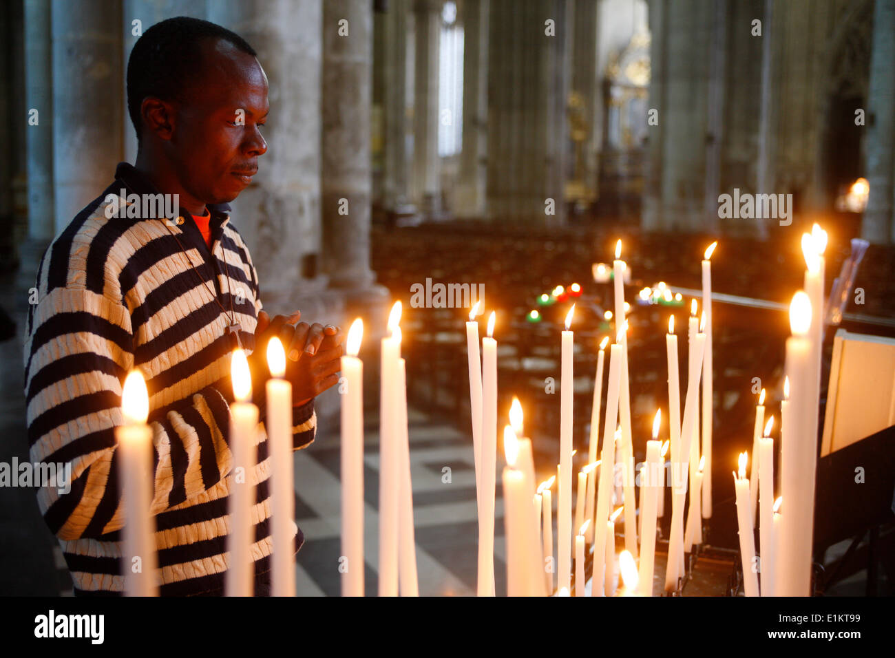 Man praying with candles in church Stock Photo Alamy