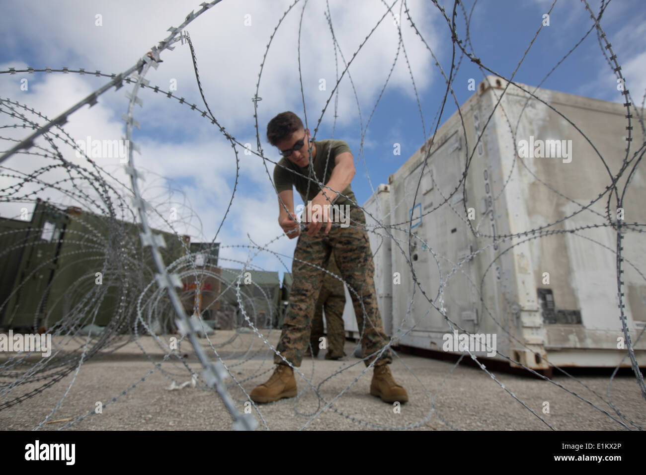 U.S. Marine Corps Lance Cpl. Alex Hogue, with Marine Aircraft Group 12, 1st Marine Aircraft Wing, sets up barbed wire at the un Stock Photo