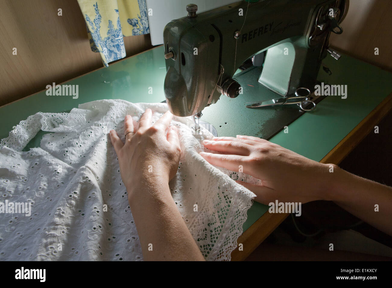 Hands of a dressmaker supporting a cloth while sewing on a sewing machine, Spain Stock Photo
