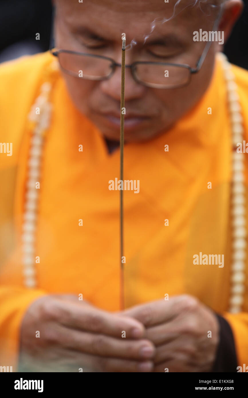 Buddhist monk holding an incense stick Stock Photo Alamy