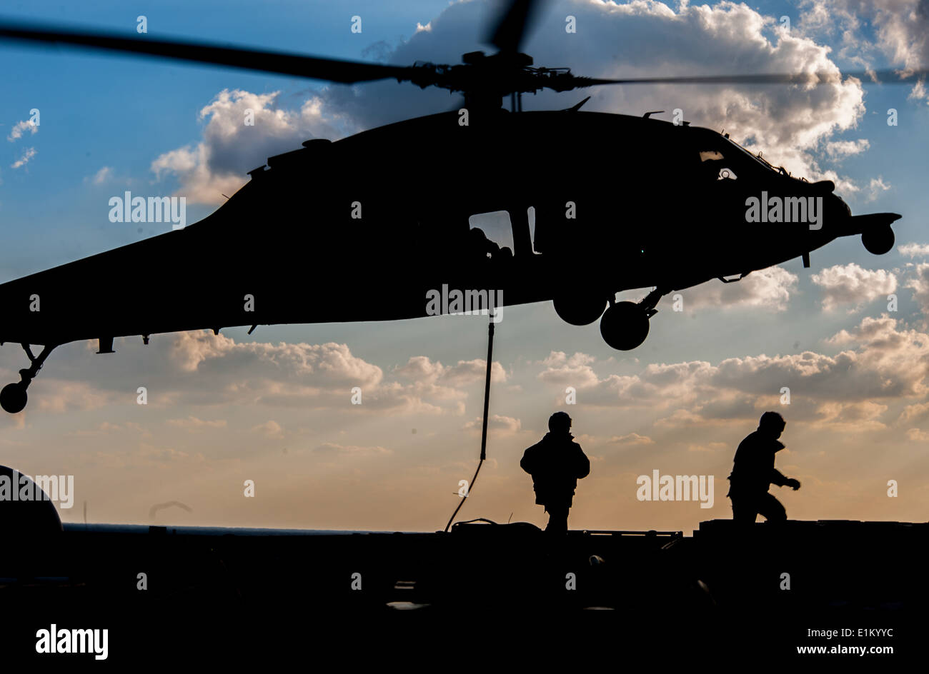 A U.S. Navy MH-60S Seahawk helicopter assigned to Helicopter Sea Combat Squadron (HSC) 25 prepares to lift ordnance from the fl Stock Photo