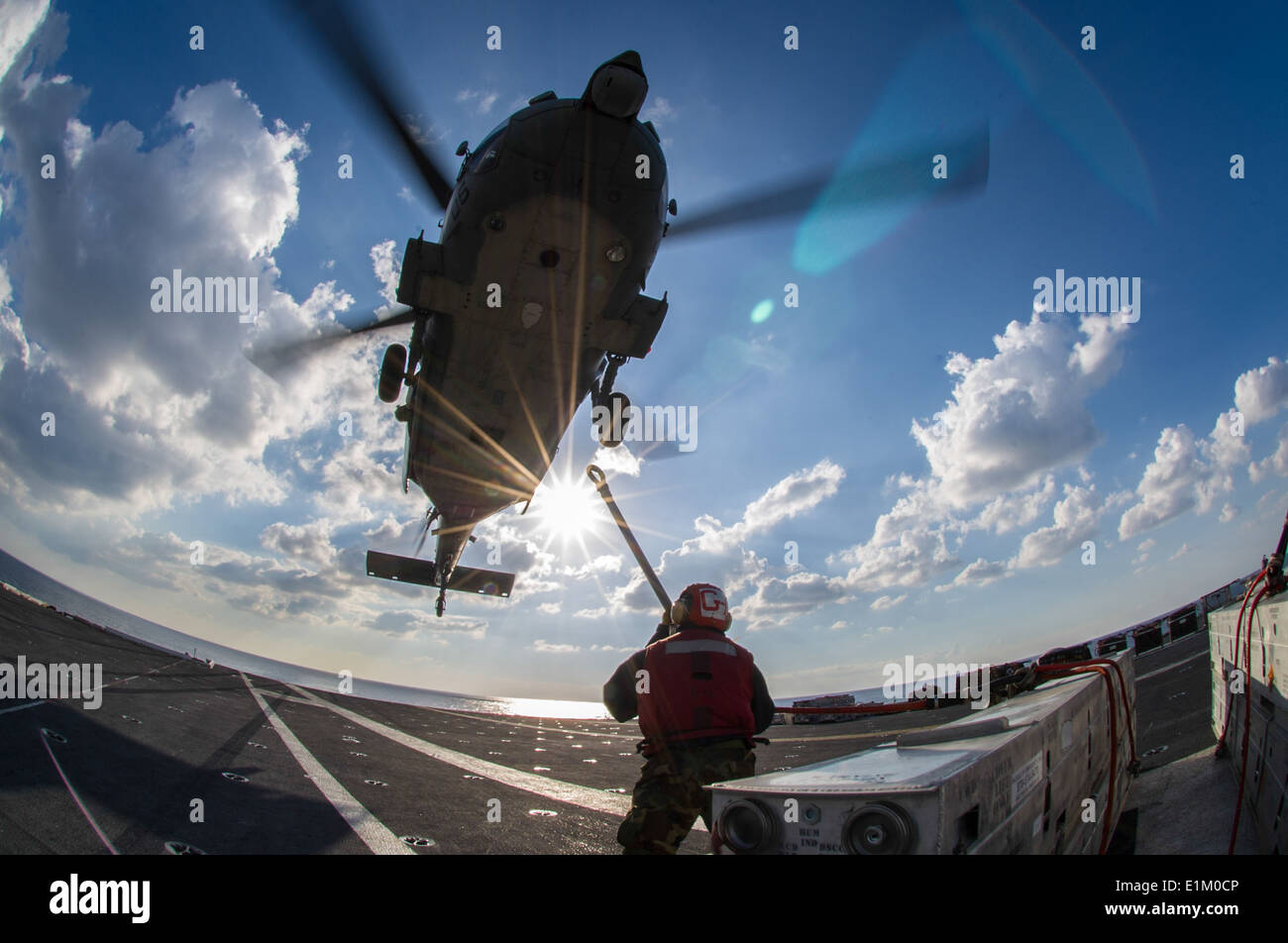 A U.S. Sailor aboard the aircraft carrier USS George Washington (CVN 73) attaches a cargo hook to an MH-60S Seahawk helicopter Stock Photo