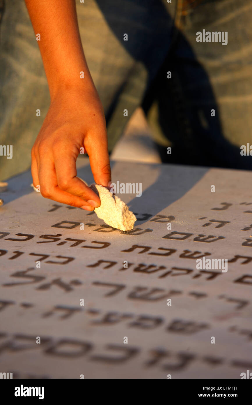 Boy placing a stone on a grave in the Mount of Olives Jewish cemetery Stock Photo