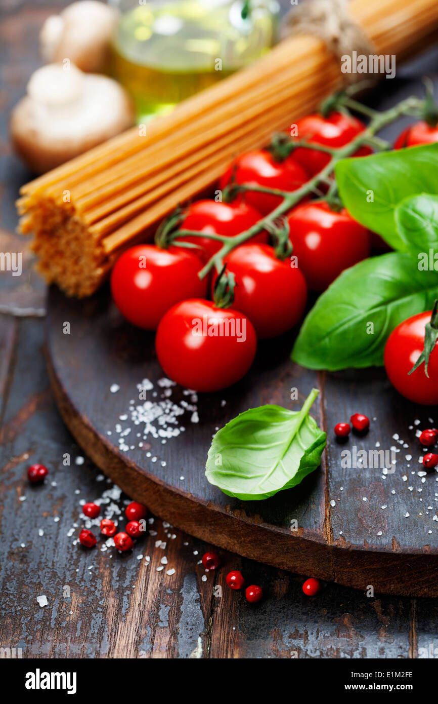 Spaghetti and tomatoes with herbs on an old and vintage wooden table Stock Photo