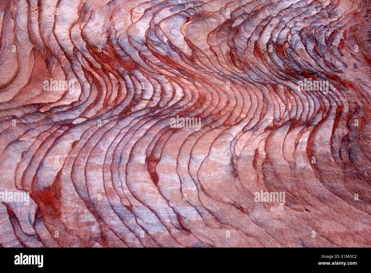 Rock composed of sandstone, which appears in layers and slopes off in shimmering color emboldened by the light and magnified by Stock Photo