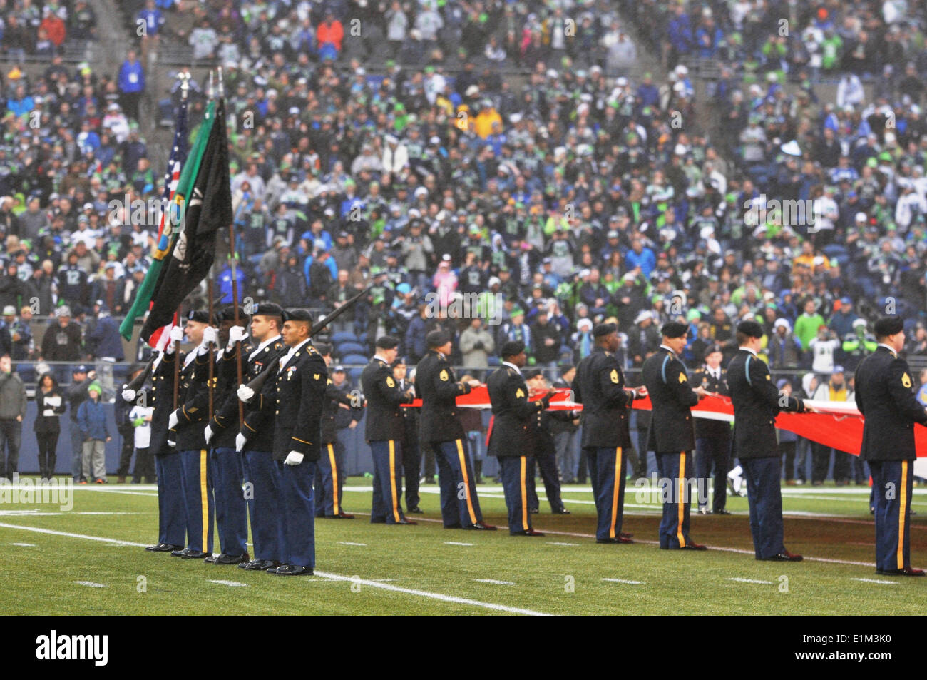 U.S. Army color guard members assigned to the 4th Stryker Brigade Combat Team, 2nd Infantry Division perform during a football Stock Photo