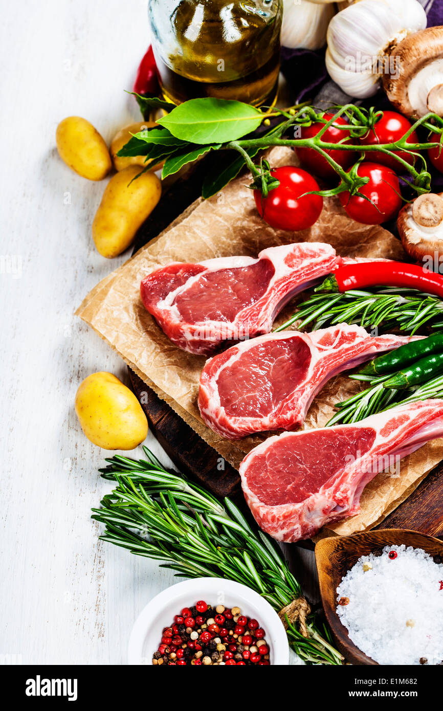 Raw lamb cutlets with vegetables, herbs and spices Stock Photo