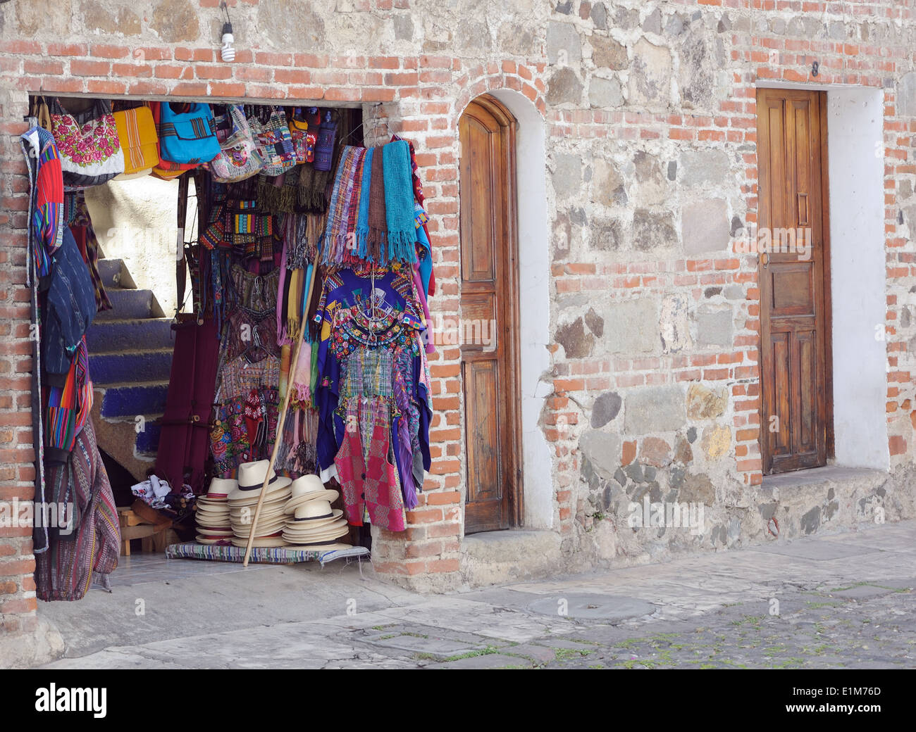 Panama hats, scarves and bags for sale in a doorway. Antigua Guatemala, Republic of Guatemala. Stock Photo