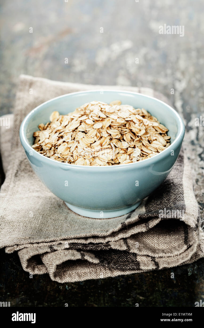 Rolled oats in a bowl on wooden board Stock Photo