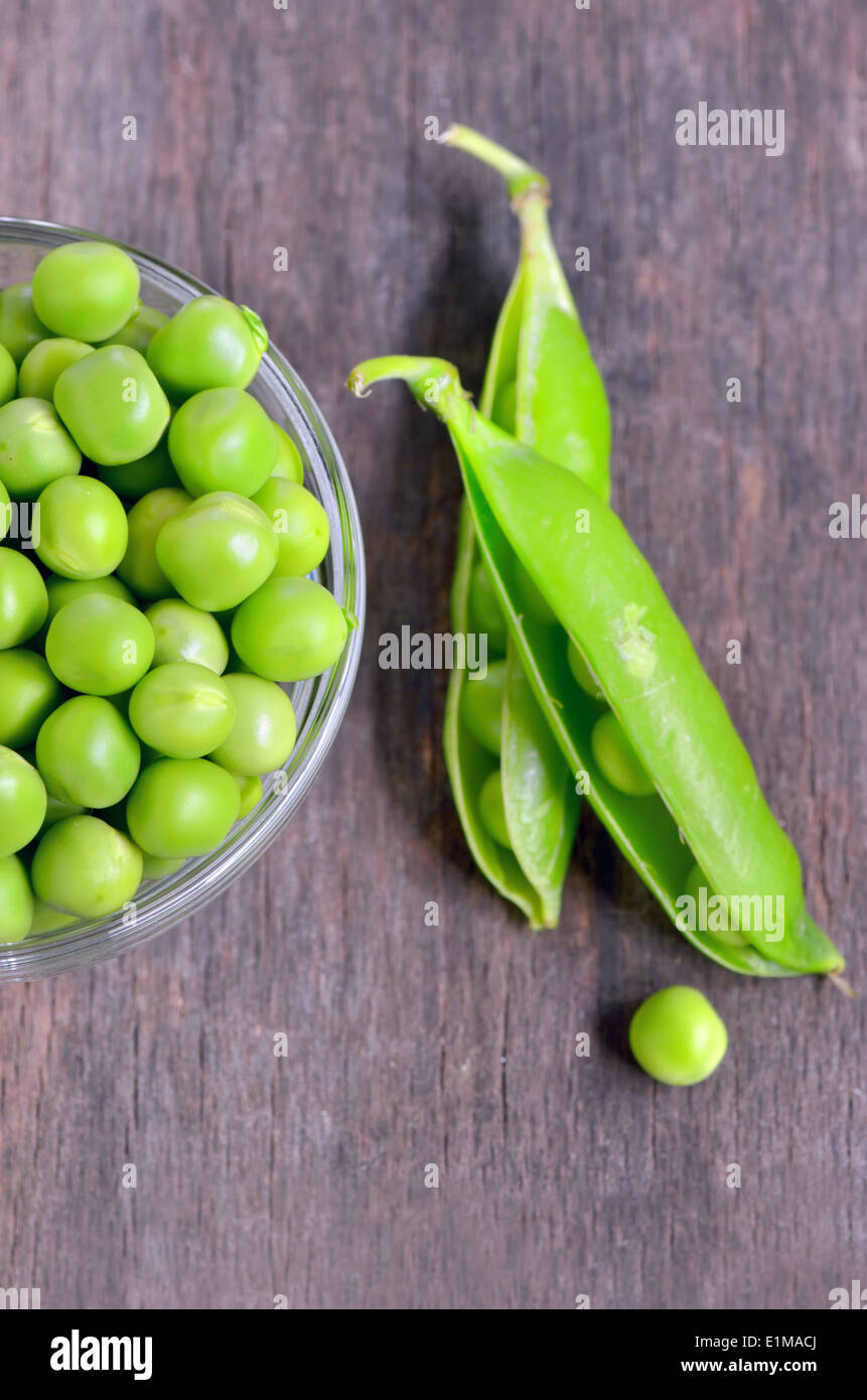 Fresh green pea pod on old wooden background Stock Photo