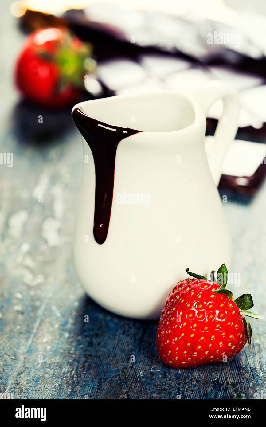 Delicious rich and thick chocolate sauce in a jug and assorted