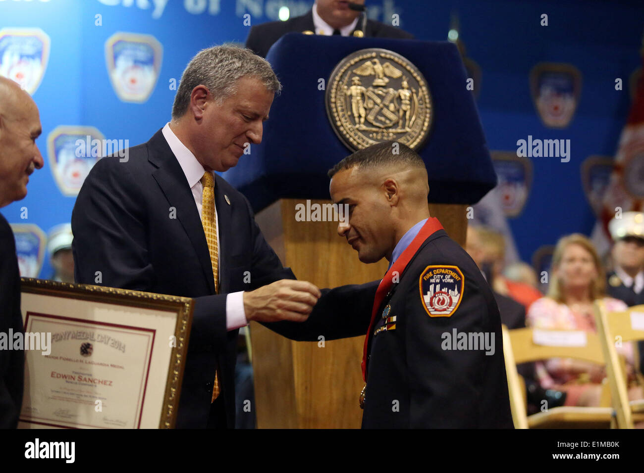 New York, New York, USA. 4th June, 2014. NYC Mayor BILL DE BLASIO, left, awards Firefighter EDWIN SANCHEZ of Rescue Company 4 the Mayor Fiorello H. LaGuardia Medal during FDNY Medal Day 2014 at the 69th Regiment Armory in New York City, New York. © Krista Kennell/ZUMAPRESS.com/Alamy Live News Stock Photo