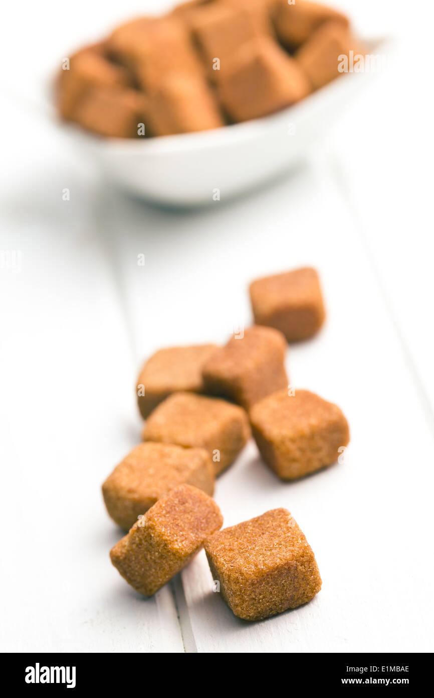 brown sugar cubes on white wooden table Stock Photo