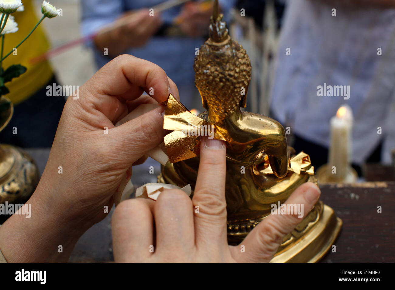Asalhapuja at Buddhapadipa temple Faithful adding a layer of gold on a Buddha statue Stock Photo